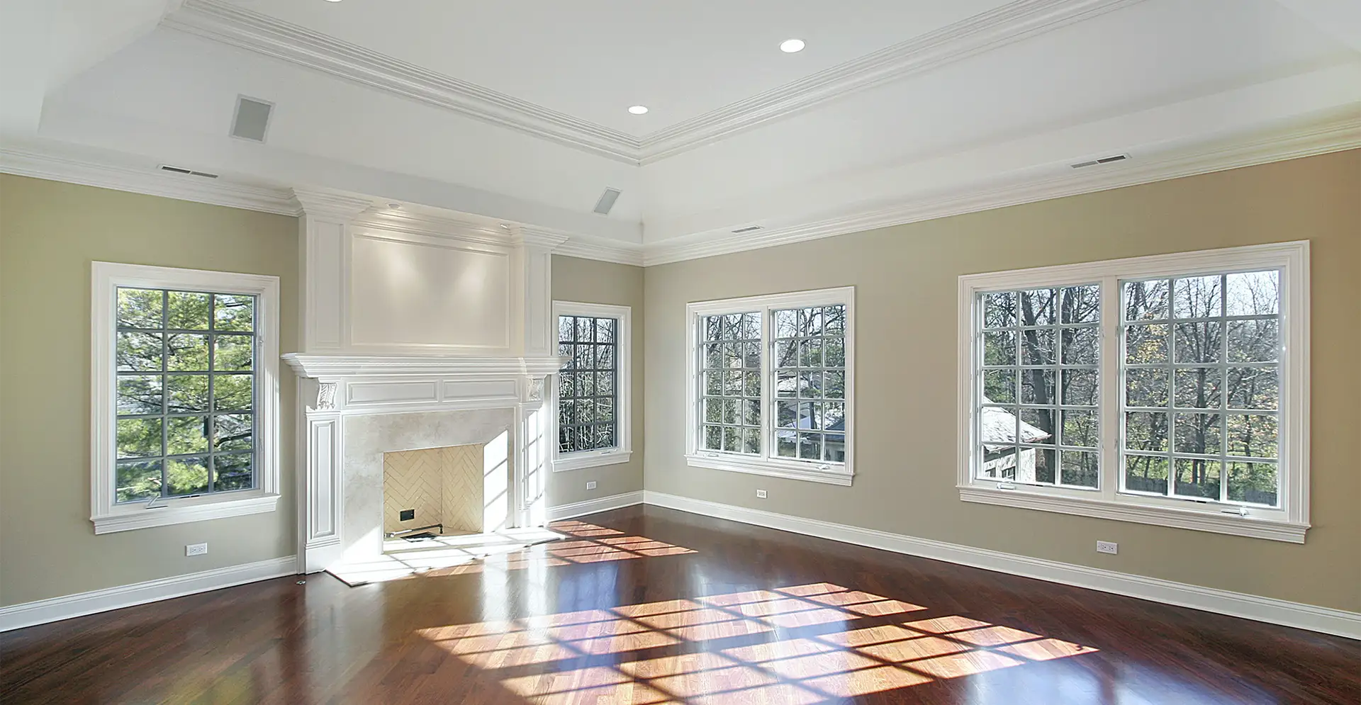 A living room featuring ornate wood moulding and window trim painted in white, located in Riverside County